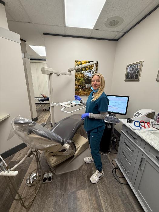 dental hygienist standing in dental exam room