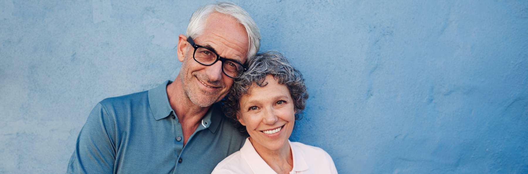A smiling older couple with dental implants in centennial co