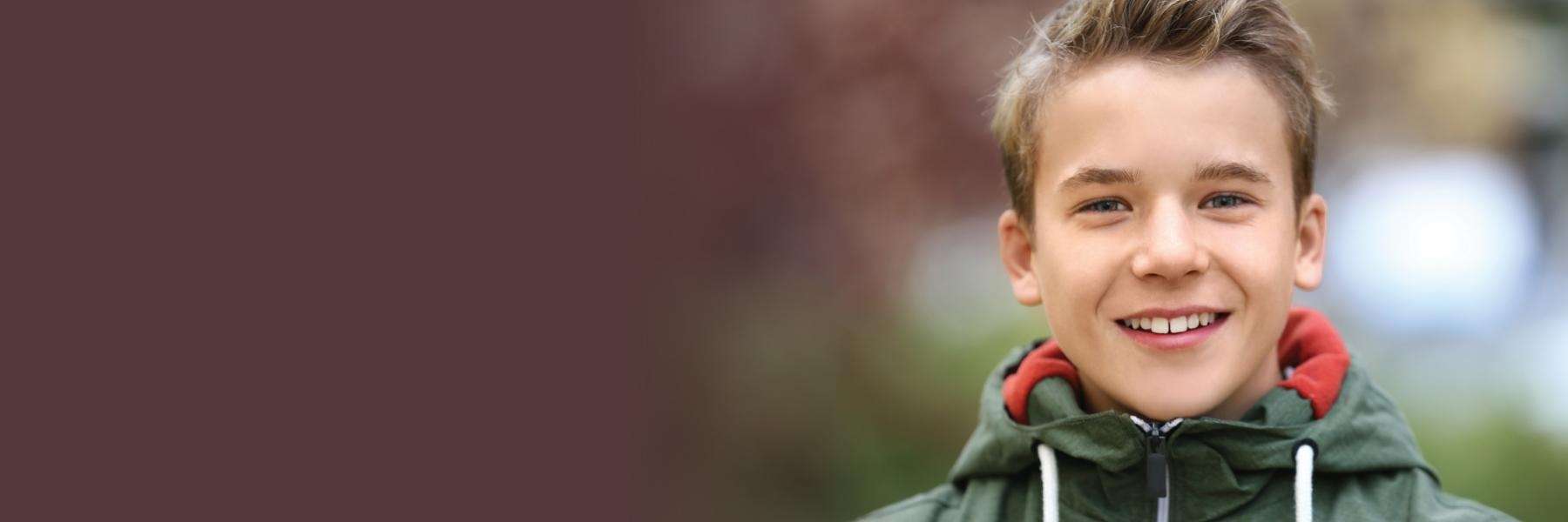 A smiling boy wearing a jacket
