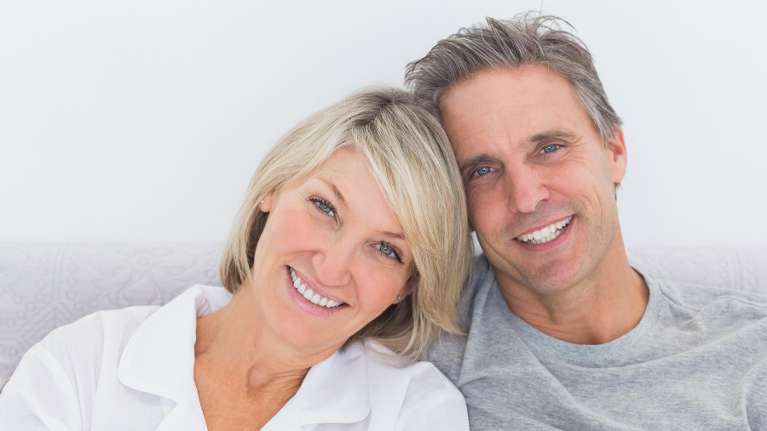 A smiling couple with dental implants in Centennial
