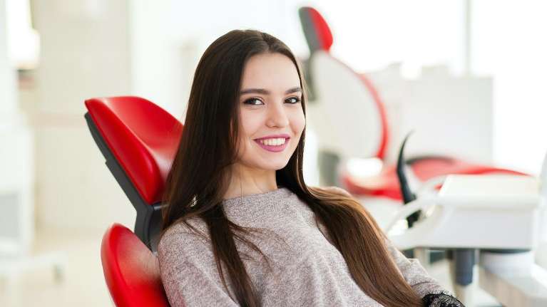woman smiling in dental exam chair | dentist centennial co